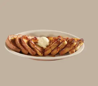 Momma’s French Toast Breakfast with syrup, eggs, and bacon at Cracker Barrel.