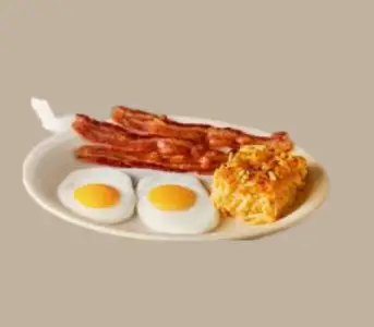 Cracker Barrel Old Timer’s Breakfast with eggs, sausage, biscuits, and gravy on a rustic wooden table.