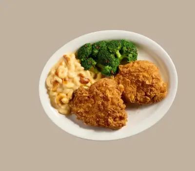Two golden fried chicken breasts served homestyle with country sides